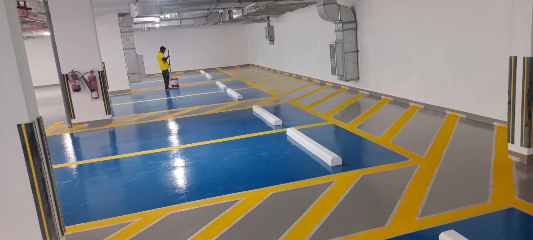 Completed epoxy parking floor with blue bays, grey traffic areas and yellow markings